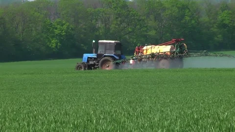 Sprayer on green wheat field contributes crop protection products Stock Footage 154694483