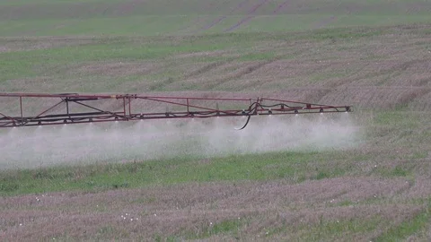 Sprayer wing spray special liquid to kill weeds in stubble field. 4K Stock Footage 71137028