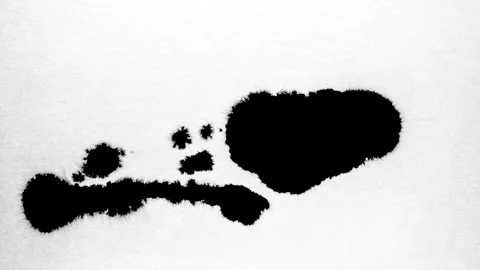 Spraying black paint on a white background Stock Footage 303171571