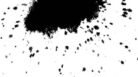 Spraying black paint on a white background Stock Footage 303171873