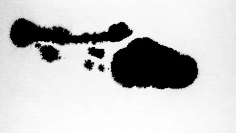 Spraying black paint on a white background Stock Footage 303171945
