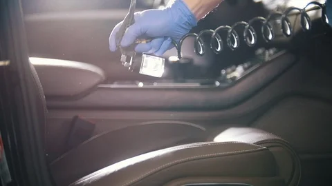Spraying the cleaning agent on leather seat inside the car Stock Footage 102727784