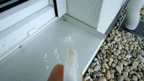 Spraying Cleaning Detergent on Metal Surface in front of Windows Stock Footage 254429689