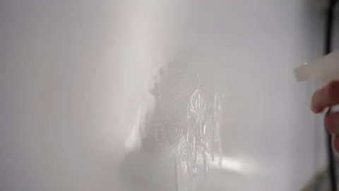 Spraying detergent onto kitchen wall, emphasizing cleaning process and Stock Footage 305993502