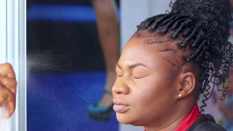 Spraying face. make up artist applying make up powder on model's face Stock Footage 239588572