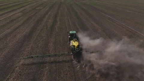Spraying field. John Deere Tractor use spray and irrigation. Stockbeeldmateriaal 212060681