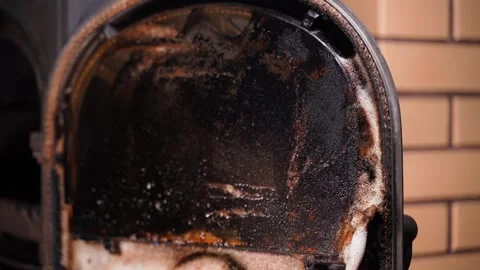 Spraying the fireplace stove window with detergent. Carbon and soot on the Stock Footage 327253149
