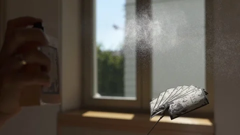 Spraying parfume in front of a window, slow motion, stock video Stock Footage 96715154