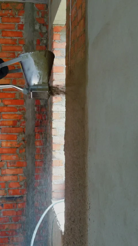 Spraying plaster onto brick wall. Vertical video. Stock Footage 321887997