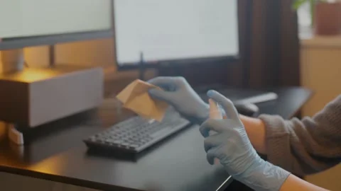 Spraying sanitizer to clean keyboard,using glowes. Covid-19 disinfection concept Stock Footage 146220930
