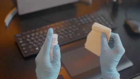 Spraying sanitizer to clean keyboard,using glowes. Covid-19 disinfection concept Stock Footage 146220962