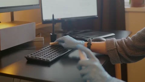 Spraying sanitizer to clean keyboard,using glowes. Covid-19 disinfection concept Stock Footage 146265900