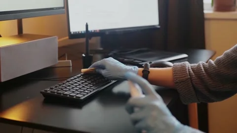 Spraying sanitizer to clean keyboard,using glowes. Covid-19 disinfection concept Stock Footage 150489975