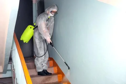 Spraying in stairwell of the house a solution from infections and Covid-19 Stock Photos