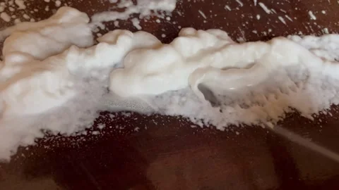 Spraying White Cleaning Foam on Dark Surface Stock Footage 345305830