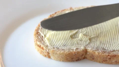 Spread Butter on Bread. Slow Motion Knife Spreading Butter over the Bread Video stock 151377076