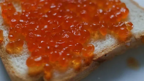 Spread caviar on white toast bread. Someone makes a snack Stock Footage 108186468