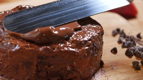 Spread chocolate cream on the cake. garnish chocolate cake.  chocolate cake deco Stock Footage 111633239