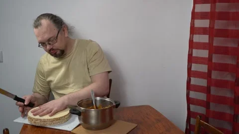 Spread cream on the cakes. Man is making a waffle cake with condensed milk Stock Footage 338011155