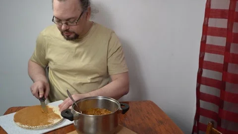 Spread cream on the cakes. Man is making a waffle cake with condensed milk Stock Footage 341229232