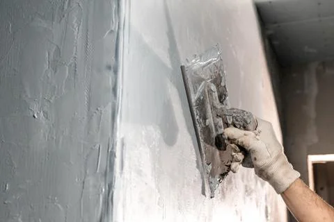 Spread the insulation on the wall with a trowel Stock-Fotos