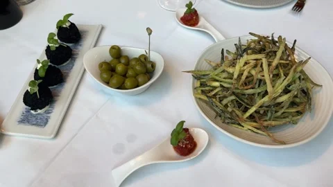 Spread of Italian starters including arancini, olives, and zucchini on table Stock Footage 340581438
