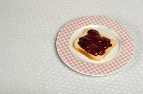 Spread jam on bread Spread jam on bread. Pink checkered plate ,model relea... Stock Photos
