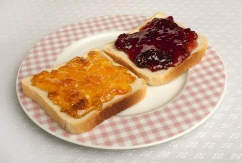 Spread jam on bread Spread jam on bread. Pink checkered plate ,model relea... Stock Photos