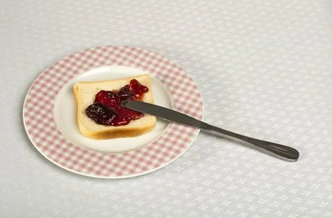 Spread jam on bread Spread jam on bread with knife. Pink checkered plate ,... Stock Photos