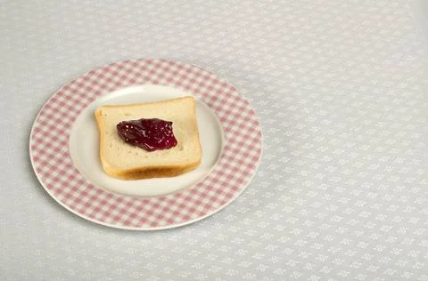 Spread jam on bread Spread jam on bread. Pink checkered plate ,model relea... Stock Photos