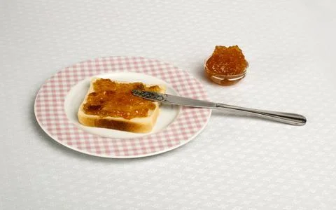 Spread jam on bread Spread jam on bread with knife. Pink checkered plate ,... Stock Photos
