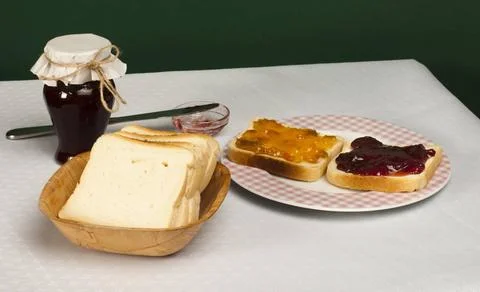 Spread jam on bread Spread jam on bread. Pink checkered plate and jar of j... Stock Photos