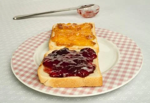 Spread jam on bread Spread jam on bread. Pink checkered plate ,model relea... Stock Photos
