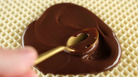 Spread liquid chocolate over layers waffle cake with golden spoon top view Video stock 234612865