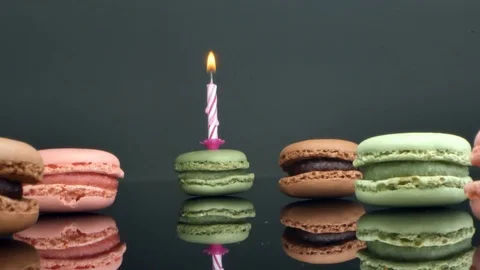 Spread macaroons and a burning candle for the holiday Stock Footage 125378064