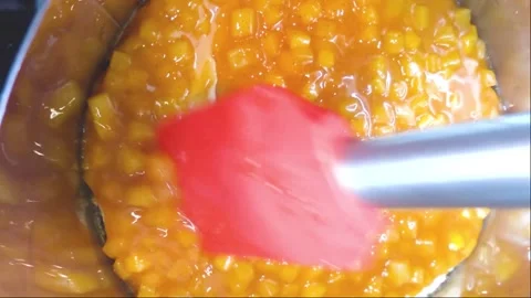 Spread the mango filling on the mousse layer inside the ring. Cooking mousse Stock Footage 204016813