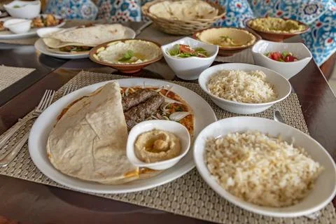 A spread of Middle Eastern cuisine made of kebab, flatbread, salad, and hummu Stock Photos
