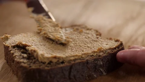 Spread pate on a slice of bread with a table knife. On the background Stock-Footage 206485697