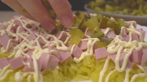 Spread pieces of pickled cucumber on boiled sausage with your hands. salad salad Stock Footage 151210252