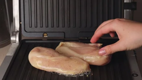 Spread the raw chicken on the electric grill. Stock Footage 292645392