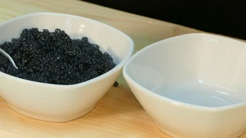 Spread the red salmon caviar in a cup next to black sturgeon caviar Stock Footage 88500339