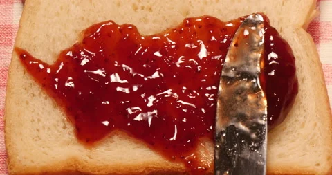 Spread strawberry jam on bread 库存影片 162603397