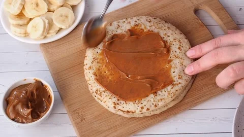 Spread thin pancakes with chocolate or cream paste. Pancakes with boiled condens Video stock 259463268