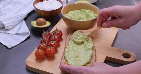 Spreading Avocado Cream on Fresh Bread Slice Stock Footage 322925380