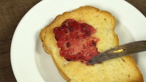 Spreading Blueberry jam on bread Stock Footage 113074842
