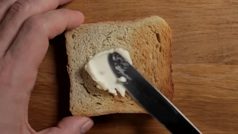 Spreading bread toast with cheese brush, close-up, selective focus, top view Video stock 154377406