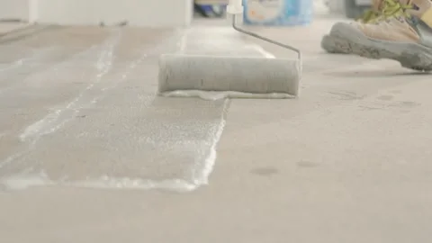Spreading building material on the floor with a roller before installing tiles. Vidéo 340914458