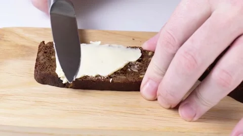 Spreading butter on bread with a knife close-up Stock Footage 147458572