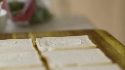 Spreading butter on bread slices to make a delicious sandwich Stock Footage 310609276