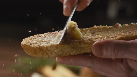 Spreading butter on ciabatta bread or French baguette for delicious Breakfast Stock Footage 123572759